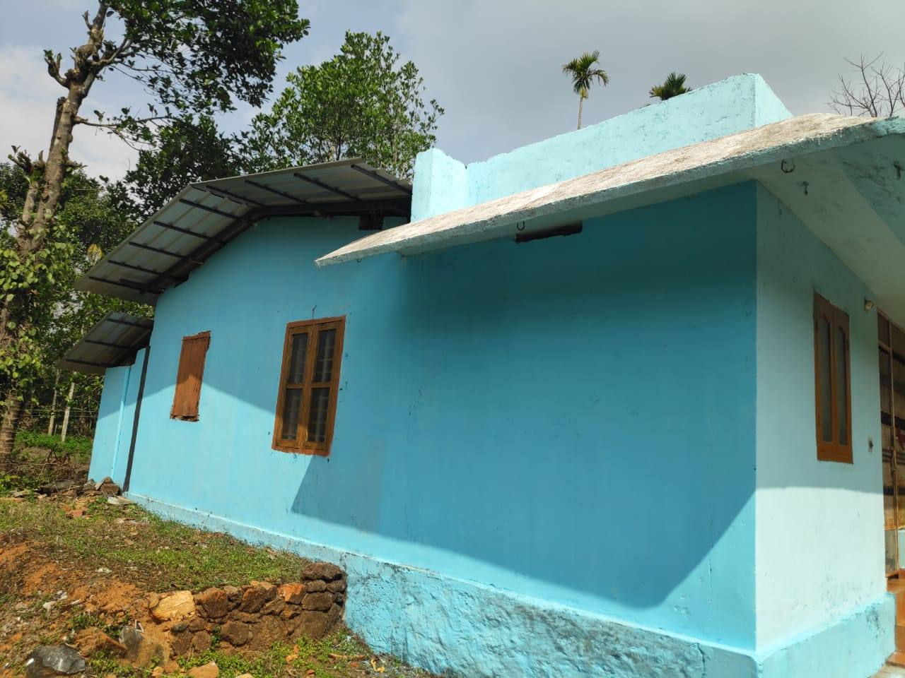 Blue farmhouse on a 1.6-acre plantation estate near the Mananthavady–Calicut highway